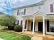 Welcoming townhouse featuring a cozy entrance with columns and well-maintained landscaping at 9615 Littleleaf Dr, Charlotte, NC 28215
