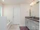 Bright bathroom featuring a granite double sink vanity and a separate tiled tub at 9727 White Chapel Nw Dr, Concord, NC 28027