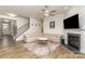 Comfortable living room featuring fireplace, modern ceiling fan and staircase to the upper level at 9727 White Chapel Nw Dr, Concord, NC 28027