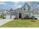 Beautiful two-story home featuring stone accents, a manicured lawn, and a two-car garage at 1005 Argentium Way, Waxhaw, NC 28173