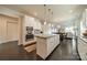 Open kitchen with stainless steel appliances, granite island, and white cabinets, perfect for entertaining at 1005 Argentium Way, Waxhaw, NC 28173