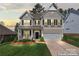 Charming two-story home with a well-manicured lawn, inviting front porch and attached two car garage at 10072 Fox Trotter Ln, Midland, NC 28107