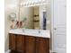 Bathroom with a double sink vanity, a large mirror, and wood cabinets at 1013 Laparc Ln, Indian Trail, NC 28079