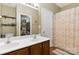 Bright bathroom featuring a double sink vanity, a shower with a floral curtain and shelves at 1013 Laparc Ln, Indian Trail, NC 28079