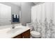 Cozy bathroom featuring a single sink vanity, toilet and shower with a white curtain at 1013 Laparc Ln, Indian Trail, NC 28079