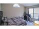 Bedroom featuring a comfortable bed, desk, window, and a light neutral color scheme, creating a cozy space at 10202 Orchard Grass Ct, Charlotte, NC 28278