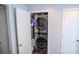 Modern laundry closet with stacked washer and dryer and white bi-fold door at 10202 Orchard Grass Ct, Charlotte, NC 28278