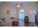 Bright living room featuring a large rounded window, hardwood floors, sofa and a ceiling fan at 10202 Orchard Grass Ct, Charlotte, NC 28278
