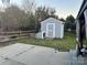 Outdoor storage shed in backyard featuring custom pet door for added convenience at 10202 Orchard Grass Ct, Charlotte, NC 28278