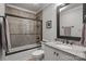 Elegant bathroom featuring a granite countertop, framed mirror, and a tiled shower with glass doors at 1033 Southwest Dr, Davidson, NC 28036