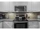 Well-equipped kitchen with stainless steel appliances, white cabinets, and granite countertops at 1033 Southwest Dr, Davidson, NC 28036