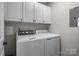Bright laundry room boasts ample cabinet space above a modern washer and dryer for convenient storage and functionality at 1033 Southwest Dr, Davidson, NC 28036