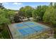 Aerial view of community tennis courts, surrounded by mature trees, offering a private, serene playing experience at 1033 Southwest Dr, Davidson, NC 28036