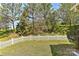 Lush backyard featuring a green lawn, tall trees, and a charming white picket fence at 1037 Hammond Dr, Matthews, NC 28104
