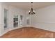 Bright dining room featuring hardwood floors, wainscoting, and french doors at 1037 Hammond Dr, Matthews, NC 28104