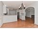 Open-concept kitchen featuring white cabinets, stainless steel appliances, and hardwood floors at 1037 Hammond Dr, Matthews, NC 28104