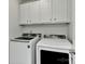 Functional laundry room with white cabinets, washer, and dryer for easy laundry days at 1037 Hammond Dr, Matthews, NC 28104