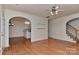 Open-concept living area features hardwood floors and arched doorways to kitchen and staircase at 1037 Hammond Dr, Matthews, NC 28104