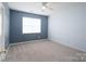 Bright bedroom features neutral carpet, blue accent wall and a ceiling fan at 1144 Spicewood Pines Rd, Fort Mill, SC 29708