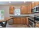 Kitchen area boasting wood cabinets, a stainless steel dishwasher and microwave, and a window at 1144 Spicewood Pines Rd, Fort Mill, SC 29708