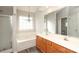 Bathroom featuring dual sink vanity, jacuzzi bathtub, glass shower, laminate floors, and a window at 11623 Black Maple Ave, Charlotte, NC 28269