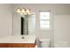 Bathroom with single sink vanity and tub with tiled surround at 11623 Black Maple Ave, Charlotte, NC 28269