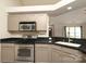 Cozy kitchen featuring stainless steel oven, microwave, black countertops, and a kitchen sink at 11623 Black Maple Ave, Charlotte, NC 28269