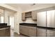 Stylish kitchen with wine rack, light grey cabinetry, stainless steel refrigerator, and black counters at 11623 Black Maple Ave, Charlotte, NC 28269
