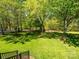 Backyard featuring a lush lawn and mature trees, providing a serene and private outdoor space at 11778 Crossroads Pl, Concord, NC 28025