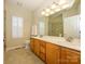 Bathroom features dual vanity sinks, ample cabinetry, and a glass enclosed shower at 11778 Crossroads Pl, Concord, NC 28025