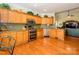 Well-equipped kitchen featuring natural wood cabinets, granite countertops, and modern appliances at 11778 Crossroads Pl, Concord, NC 28025
