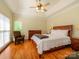 Well-lit main bedroom includes a ceiling fan, large window, and hardwood floors at 11778 Crossroads Pl, Concord, NC 28025