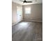 Bedroom filled with natural light features gray plank flooring and a closet at 11817 Five Cedars Rd, Charlotte, NC 28226