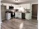 Bright kitchen with white cabinets, stainless steel appliances, and wood-look flooring at 11817 Five Cedars Rd, Charlotte, NC 28226
