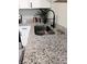 Close-up of kitchen sink with granite countertops, stainless steel fixtures, and white cabinets at 11817 Five Cedars Rd, Charlotte, NC 28226