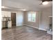 Open-concept living room with wood-look floors and a doorway leading to the kitchen at 11817 Five Cedars Rd, Charlotte, NC 28226
