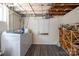 Unfinished basement area showing laundry machines, shelving, and utilities, with concrete walls and flooring at 119 Meadowbrook Ln, Davidson, NC 28036
