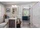 Tastefully decorated bathroom with a modern vanity, framed mirror, and doorway view into bedroom at 119 Meadowbrook Ln, Davidson, NC 28036
