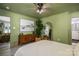 Another view of the green bedroom, featuring a dresser, artwork, and a decorative mirror at 119 Meadowbrook Ln, Davidson, NC 28036