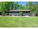 Charming one-story home with lush front lawn and mature landscaping at 119 Meadowbrook Ln, Davidson, NC 28036
