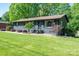 Charming one-story home with lush front lawn and mature landscaping at 119 Meadowbrook Ln, Davidson, NC 28036