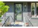 Close up view of front door with railing and lush landscaping at 119 Meadowbrook Ln, Davidson, NC 28036