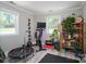 Bright workout space featuring natural light, exercise equipment, wood floors, and a vibrant bookcase at 119 Meadowbrook Ln, Davidson, NC 28036