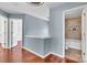 Hallway featuring hardwood floors, blue accent wall, and bathroom at 1216 Stourbridge Lion Dr, Charlotte, NC 28213