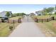 A long driveway leading to a gated community with mature landscaping at 123 Pumice Dr, Statesville, NC 28625