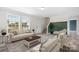 Staged living room featuring neutral tones, comfortable seating, and large windows at 123 Pumice Dr, Statesville, NC 28625