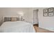 Cozy bedroom with a white bed, neutral decor, and an open doorway at 14018 Wilson Mac Ln, Charlotte, NC 28278