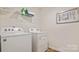 Functional laundry room with a washer, dryer, and storage shelves at 14018 Wilson Mac Ln, Charlotte, NC 28278