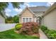 Welcoming home entrance featuring decorative shrubbery, glass front door, and charming shingle detail at 141 Ivy Creek Ln, Mooresville, NC 28115