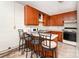 Compact kitchen featuring retro wood cabinets, linoleum flooring, and breakfast bar seating at 1444 Harris St, Statesville, NC 28677
